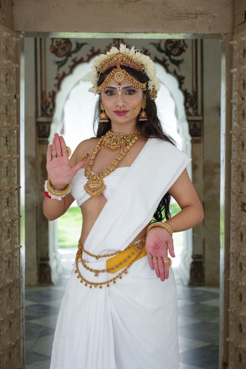 Free Portrait of a woman in traditional Indian attire resembling Saraswati in a styled photoshoot. Stock Photo