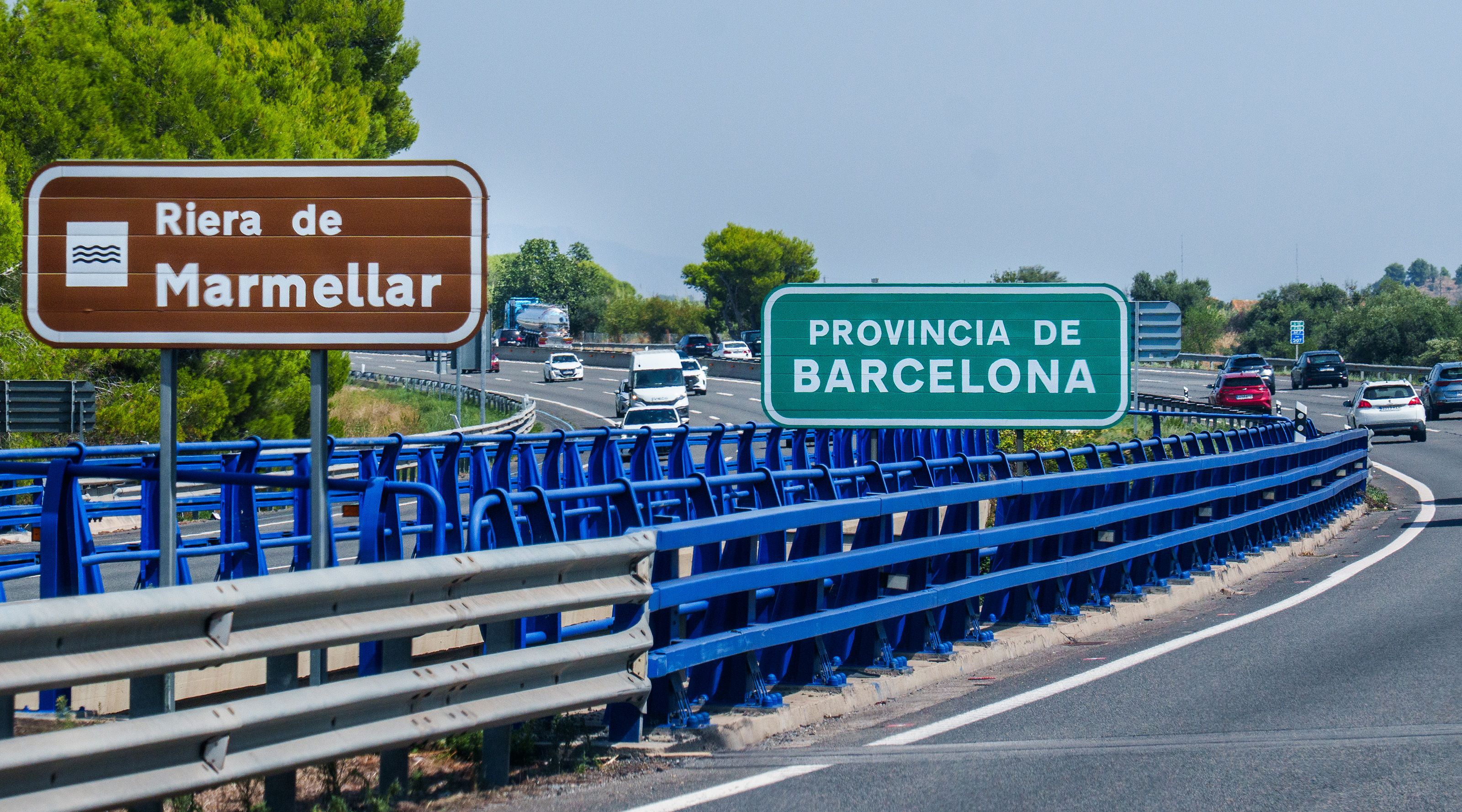 Highway view in Barcelona Province with directional signs and moving vehicles.