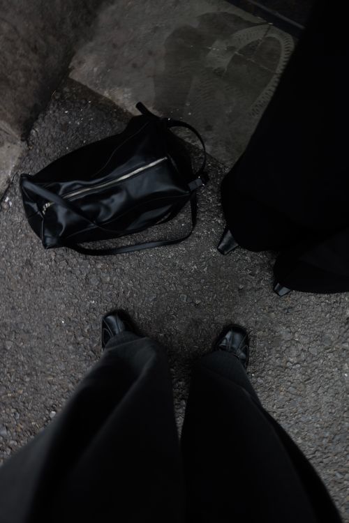 Free Aerial perspective of feet and a bag on an outdoor pavement. Stock Photo