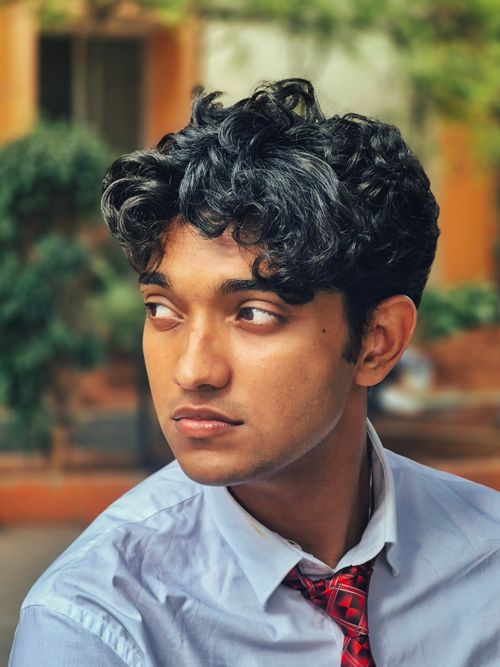 Free Portrait of a young adult man in formal attire outdoors, looking contemplative. Stock Photo