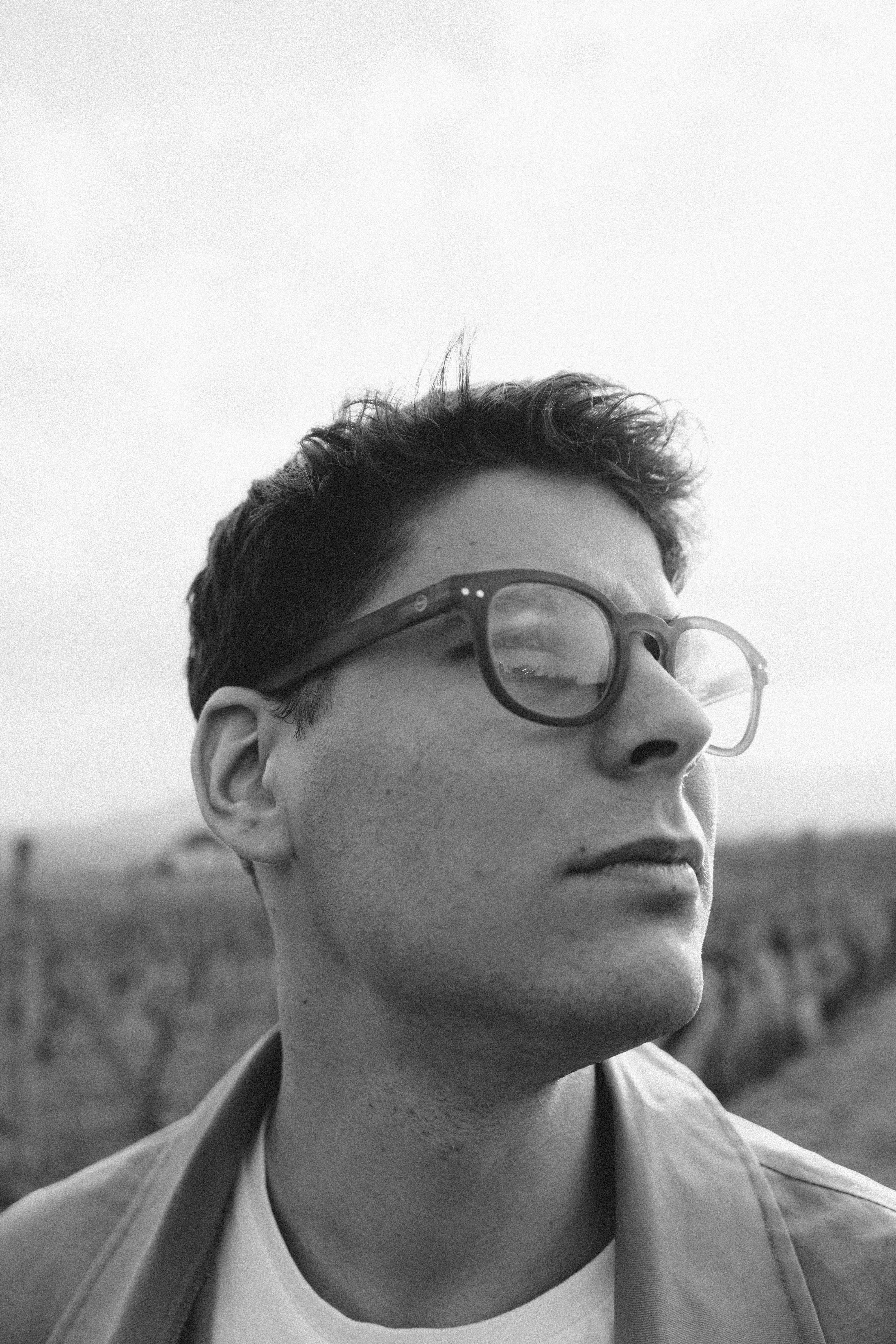 Black and white portrait of a man in glasses reflecting in Košice, Slovakia.