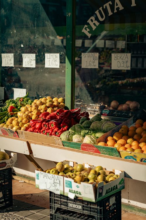 Free Colorful fruits and vegetables on a market stall in Bilbao, Spain, under warm sunlight. Stock Photo
