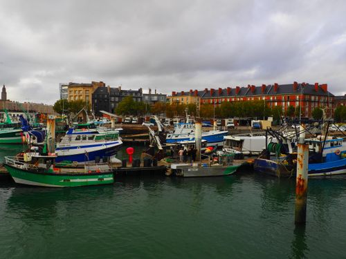 Free A vibrant scene of fishing boats docked in Le Havre harbor, Normandie, showcasing rich architecture. Stock Photo