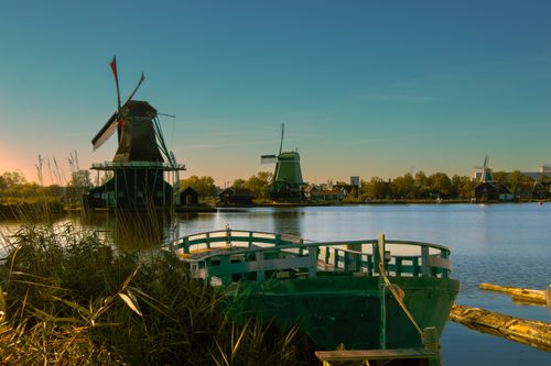 Free A tranquil view of windmills at Zaanse Schans, reflecting in the water during autumn. Stock Photo