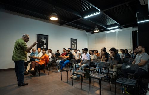 Free Participants attentively listen to a speaker in a contemporary indoor seminar setting. Stock Photo