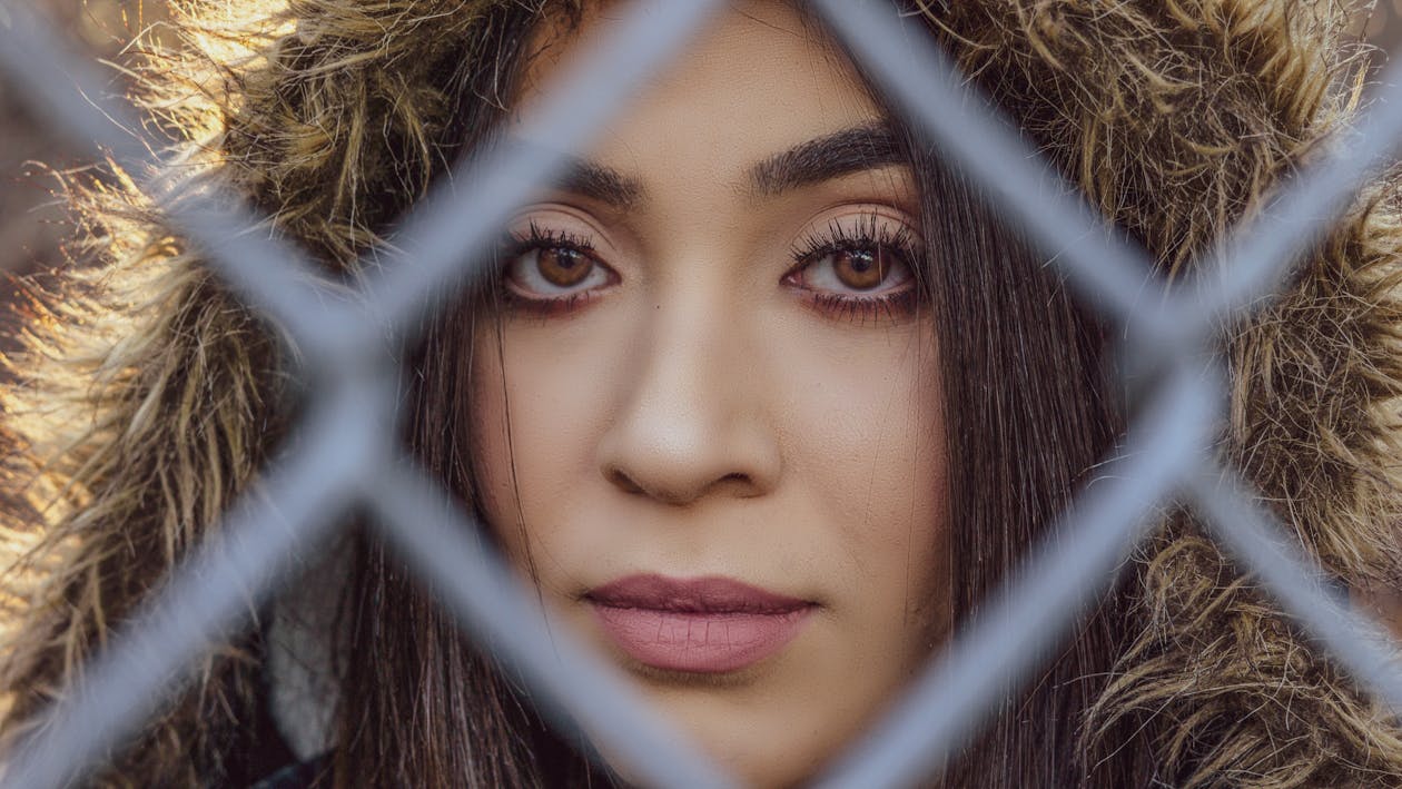 Woman Behind Gray Metal Fence