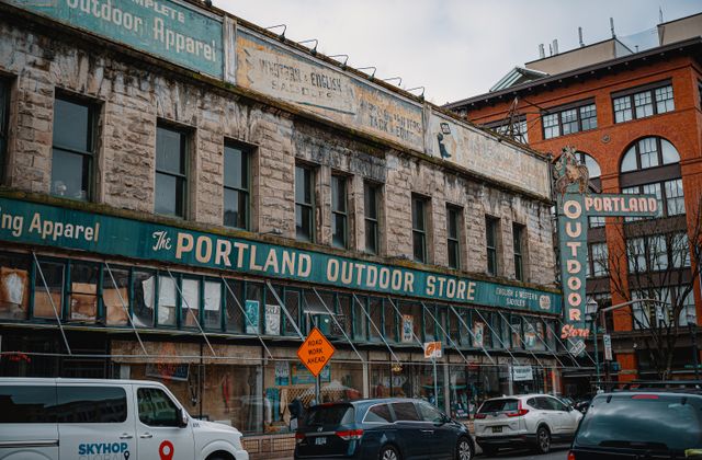 Street view of the iconic Portland Outdoor Store with vintage signage and urban scenery. — arriving in Portland