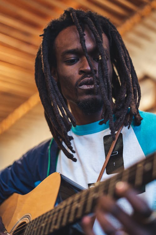 Man in Blue and White Crew Neck Shirt Holding Brown Acoustic Guitar