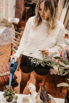 一名妇女在室内用蓝色喷壶给植物浇水，环境休闲而宁静