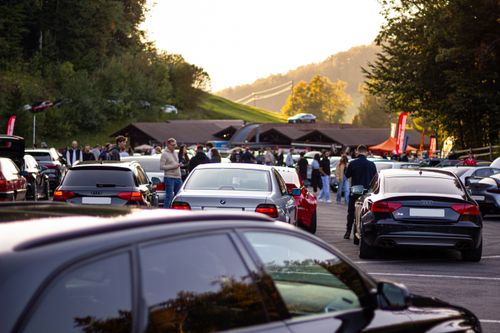 Free A lively outdoor car gathering with people and various cars on a scenic hill under a clear sky. Stock Photo