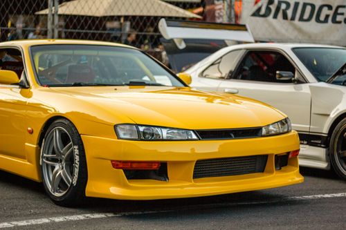 Free Close-up of a modified yellow sports car at an outdoor auto show. Stock Photo
