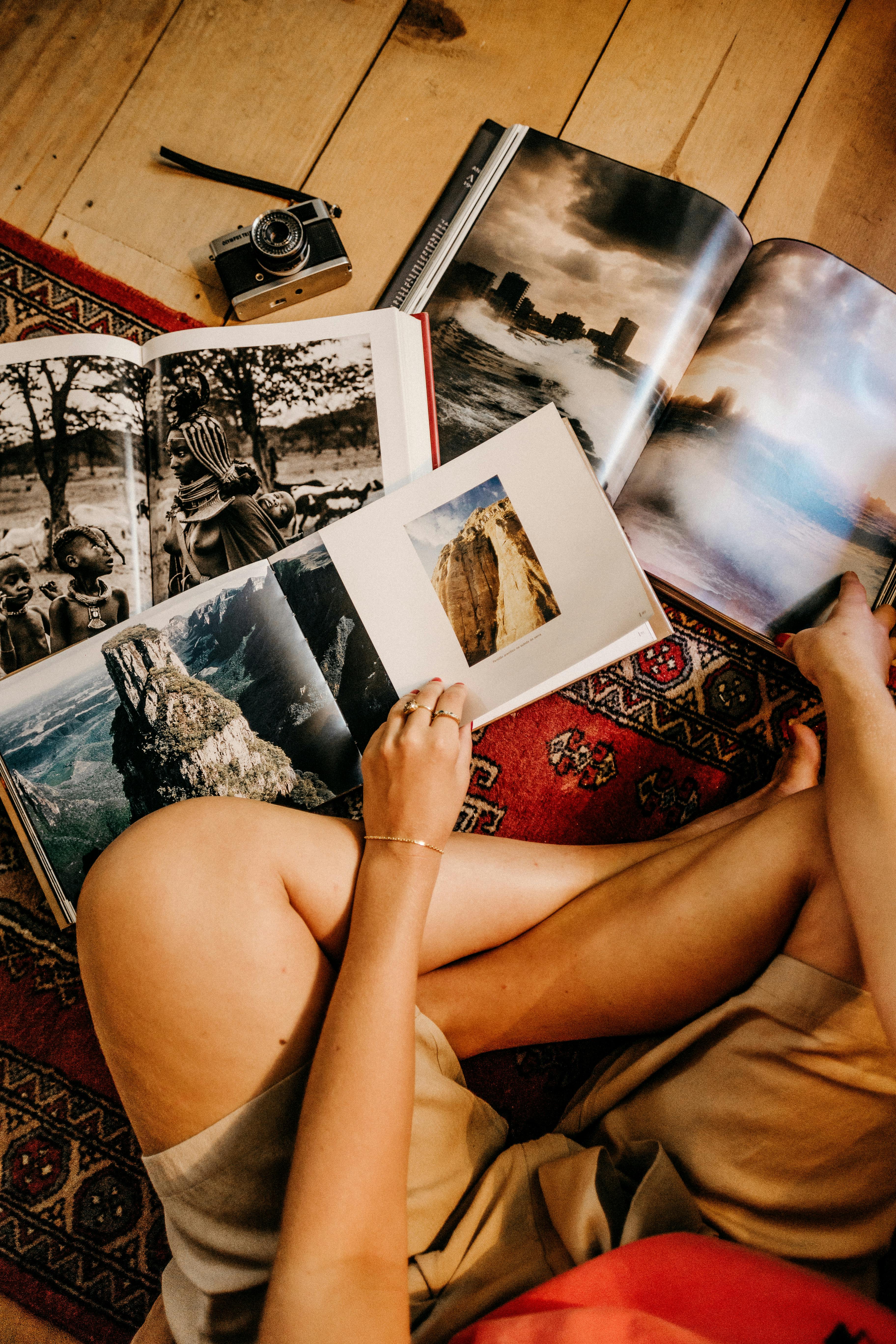 person sitting on a carpet holding books