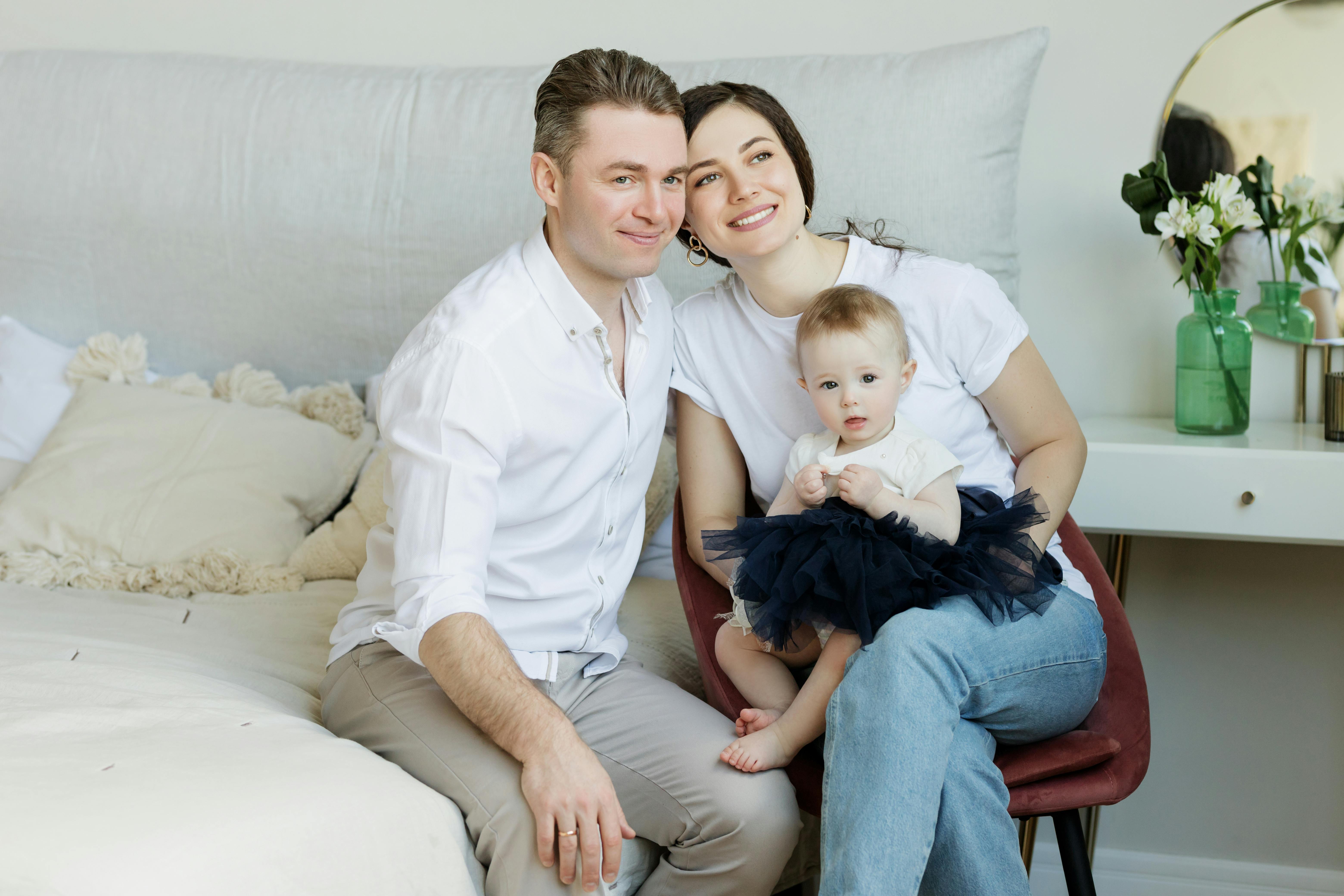 photo of couple with a baby sitting