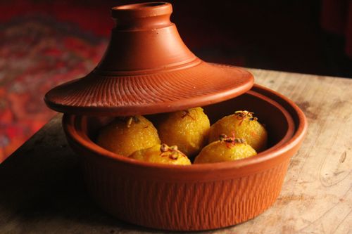 Free Close-up of Indian sweets in a rustic clay pot with warm tones. Stock Photo