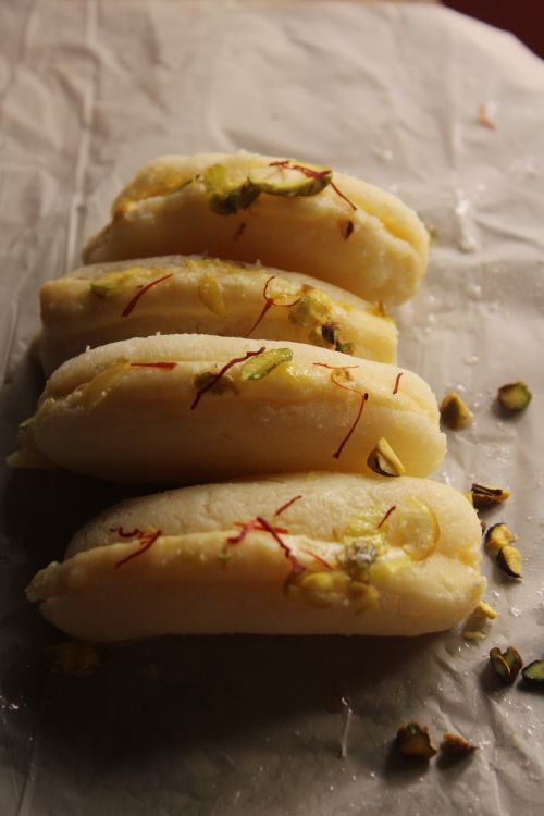 Free Indian Soan Papdi with saffron and pistachio garnish on parchment paper. Stock Photo