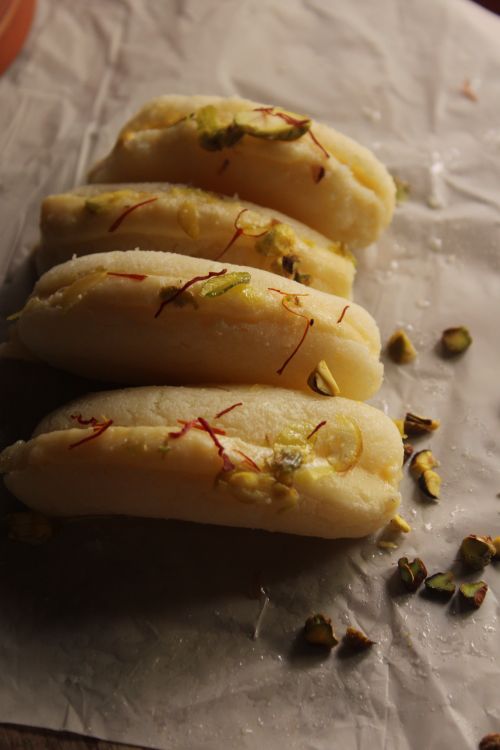 Free Close-up of traditional Indian Kaju Roll garnished with pistachio and saffron on parchment. Stock Photo