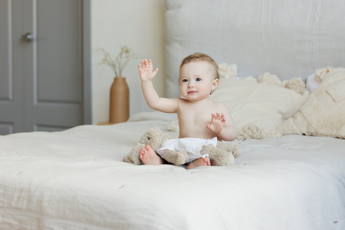 Free Baby Sitting on Bed Stock Photo