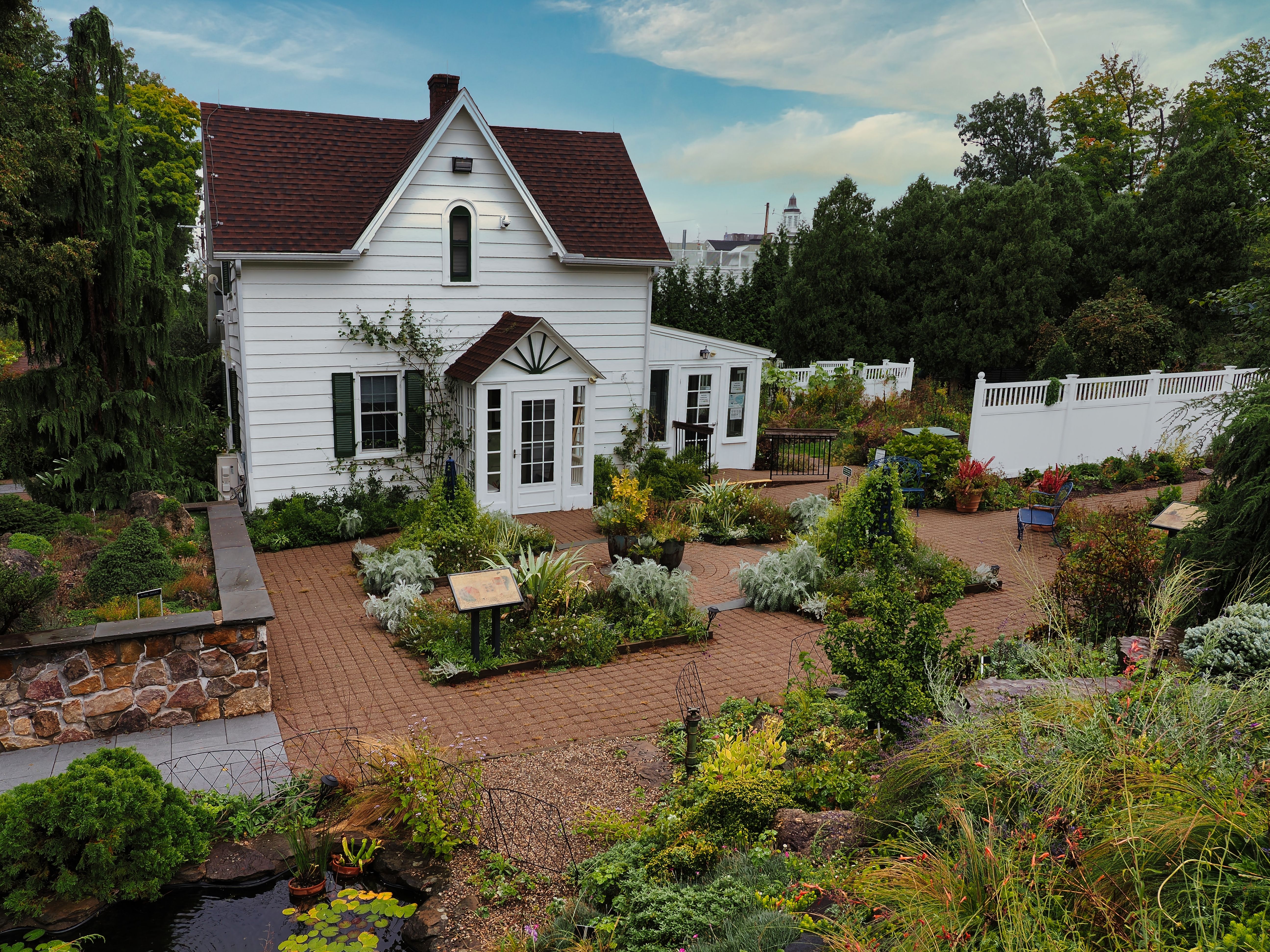 A picturesque white house surrounded by a vibrant garden in Morristown, New Jersey, USA.