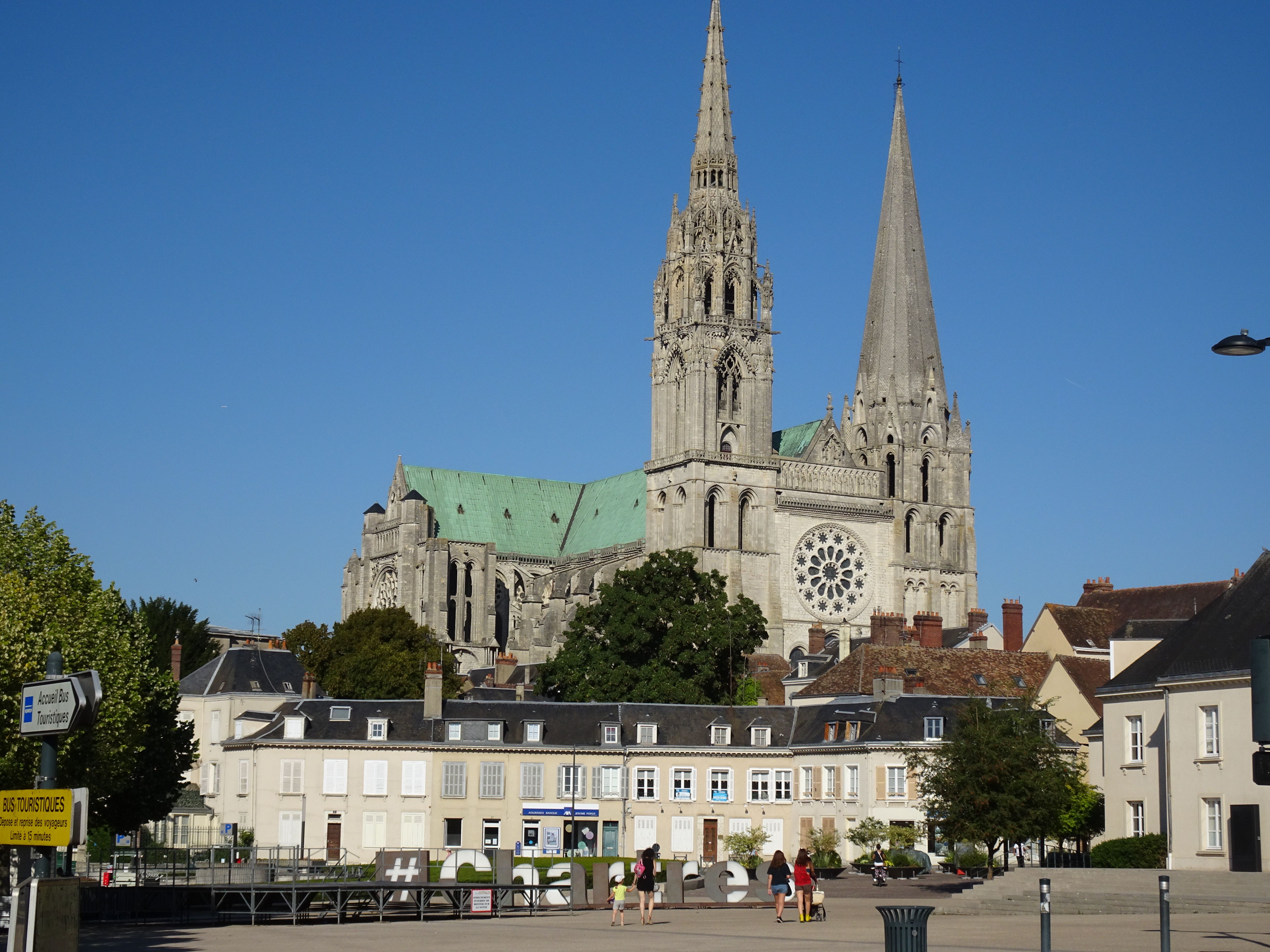 Gothic Chartres Cathedral with spires under clear blue sky in Chartres, France.