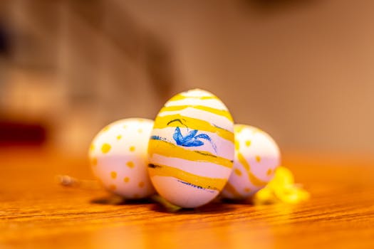 Decorative Easter eggs with yellow and blue designs on a wooden table.
