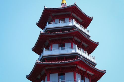 Free Striking image of a traditional pagoda with red and white tiers, set against a clear blue sky. Ideal for cultural and architectural themes. Stock Photo