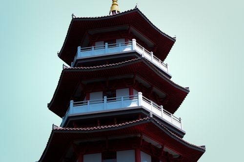 Free A close-up view of a traditional multi-tiered Asian pagoda with ornate roof detail against a clear blue sky. Stock Photo