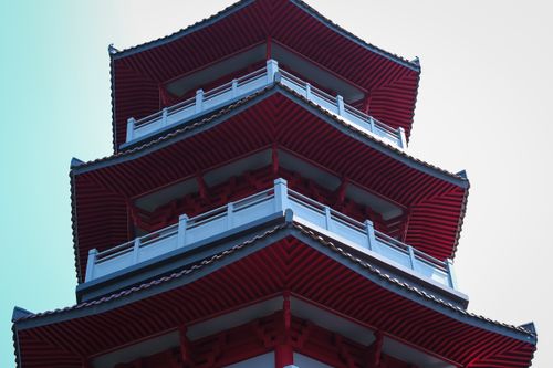 Free A close-up angle of a red pagoda tower under a clear sky, showcasing traditional architecture. Stock Photo