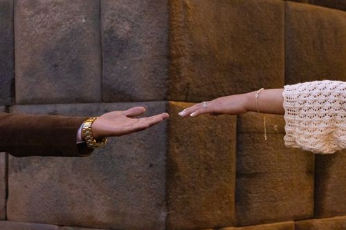 Free A man and woman reaching out their hands on a stone background. Symbolic of connection and unity. Stock Photo
