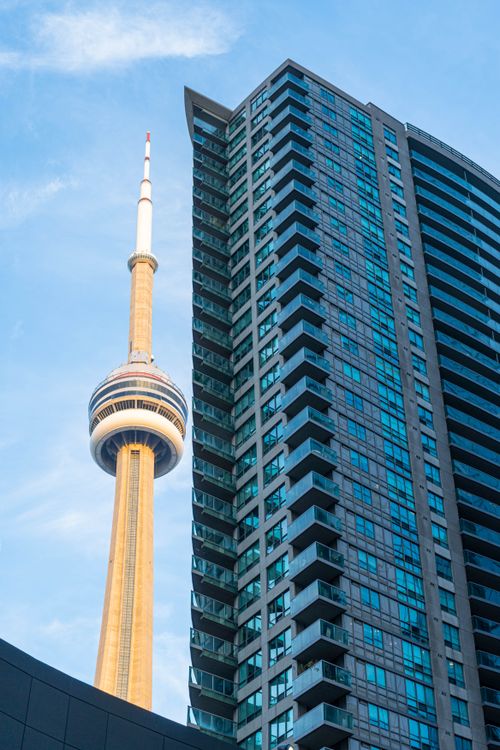Free Close-up of the CN Tower adjacent to a modern skyscraper in Toronto, Canada. Stock Photo