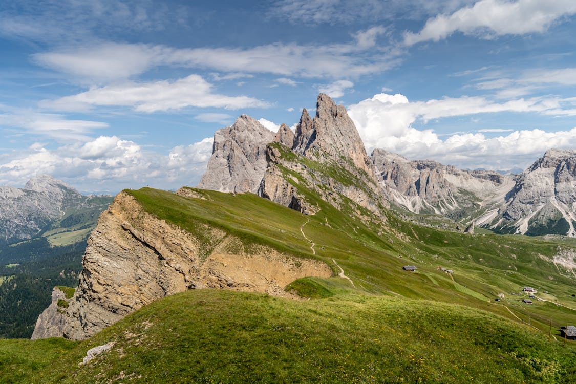 Green Grass Field And Mountain Under Blue Sky