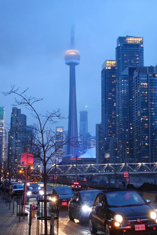 Free Dusk view of cars and the illuminated CN Tower amidst Toronto's cityscape. Stock Photo
