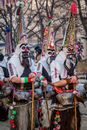 People Wearing Costumes and Masks Holding Sticks