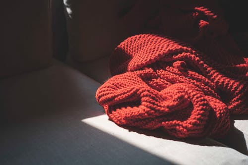 Free Red Knit Textile on Gray Surface Stock Photo