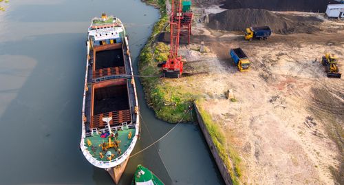 Free Aerial view of a large cargo ship unloading coal at a dockyard in Dhaka, Bangladesh. Stock Photo