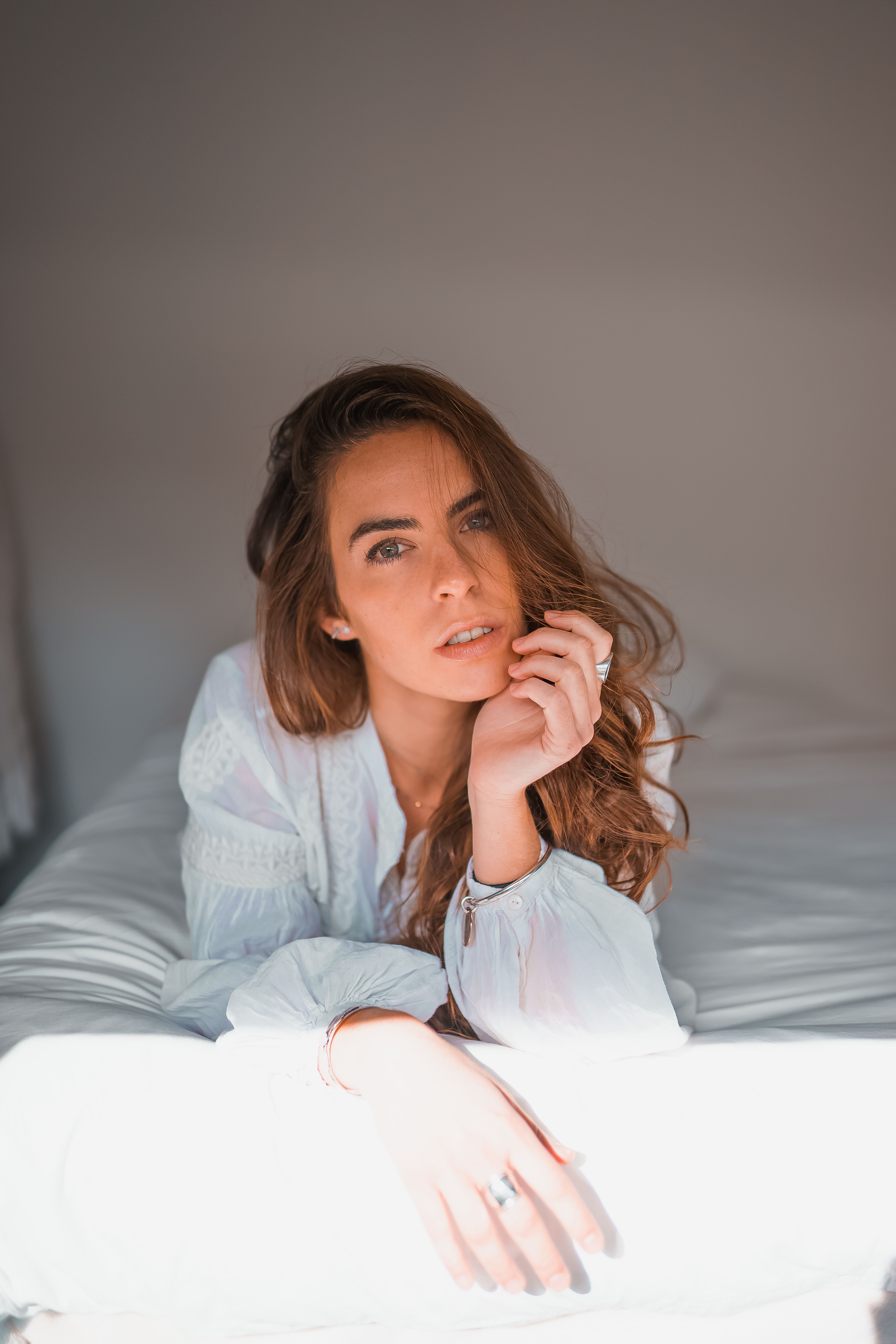 Woman In White Long Sleeve Shirt Lying On Bed · Free Stock Photo