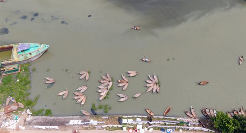 Free A captivating aerial view showing wooden boats arranged in a flower-like pattern on a calm river. Stock Photo
