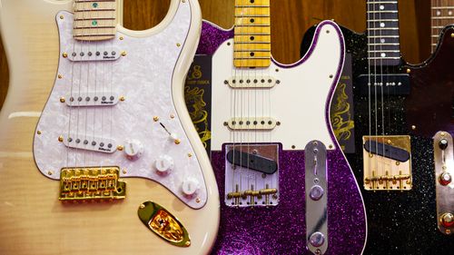 Free Three colorful electric guitars showcased in a row, highlighting unique designs and vibrant finishes. Stock Photo