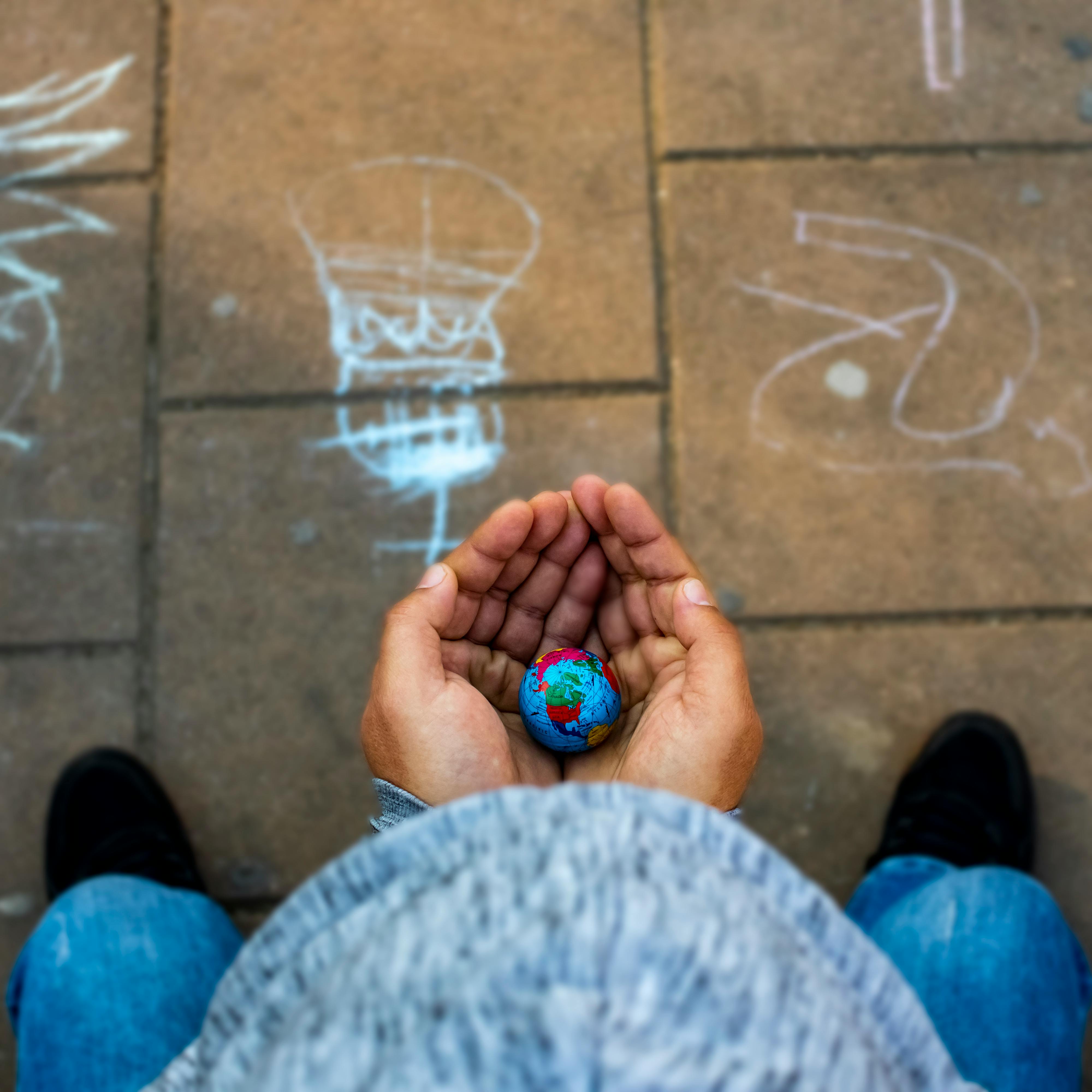 A Person Holding a Small Globe