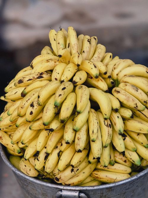 Free Abundant bunch of ripe bananas stacked in a market setting, showcasing vibrant yellow color and freshness. Stock Photo