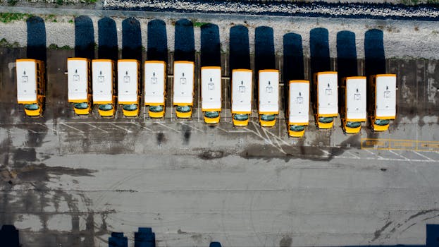 Overhead shot of yellow school buses parked in an organized row.