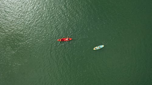 People Riding On Red Boat In The Middle Of The Sea