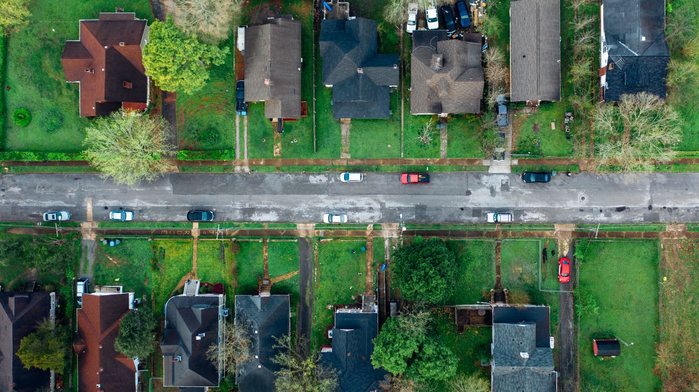 Aerial view of a residential neighborhood under a mature tree canopy
