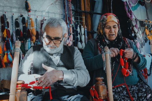 Elderly artisans weaving traditional textiles in Şanlıurfa, Türkiye, showcasing cultural heritage.