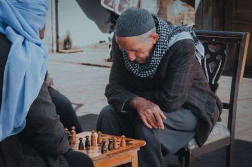 Free Two senior men engage in a thoughtful chess match outdoors in Şanlıurfa, Türkiye. Stock Photo