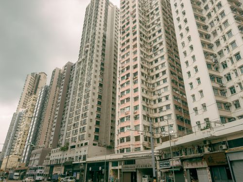 Free Wide view of Hong Kong's tall residential skyscrapers under a cloudy sky, showcasing urban density. Stock Photo