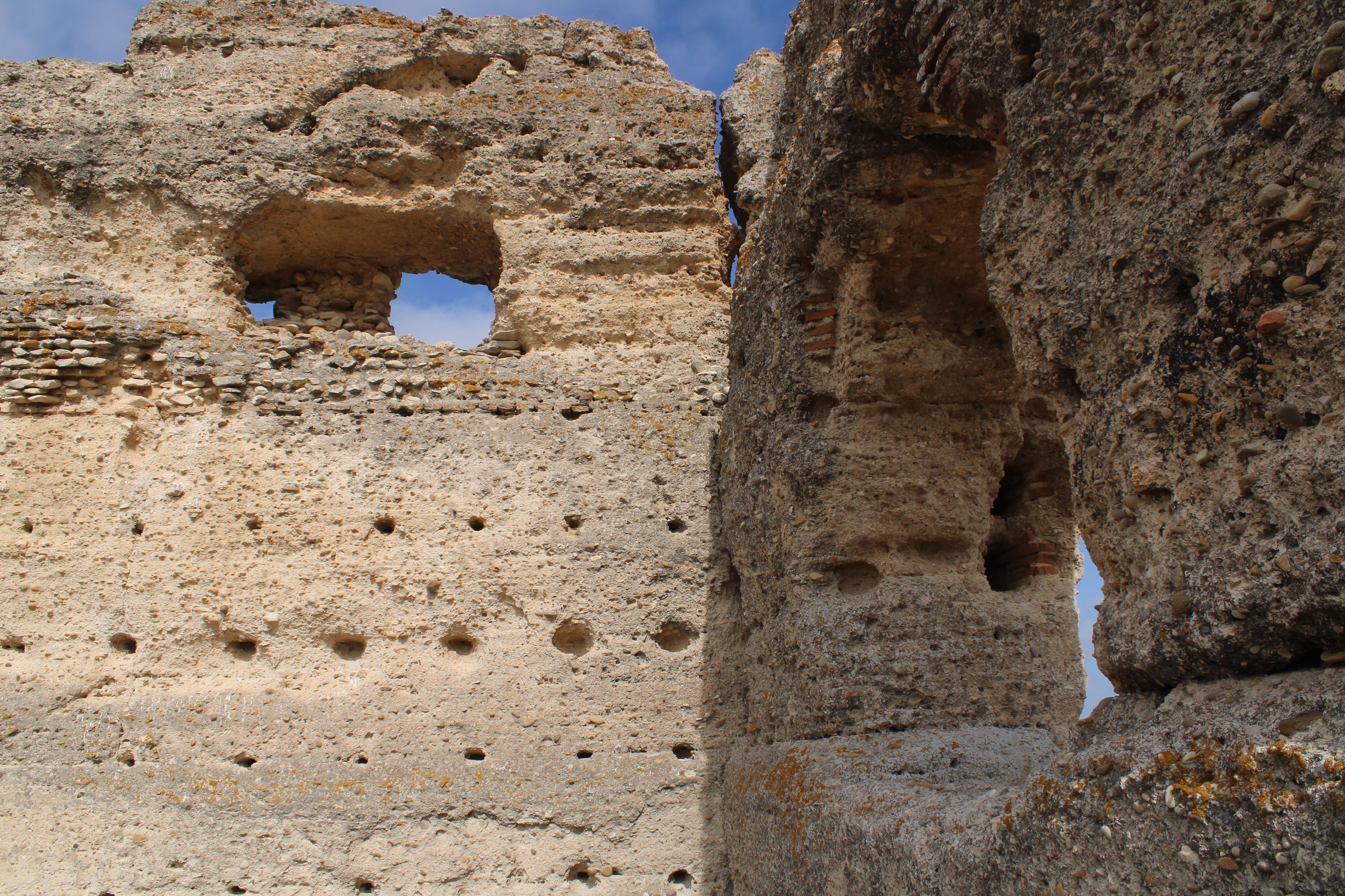 Detailed view of ancient fortress ruins in Jerez de la Frontera, showcasing historical architecture against a blue sky.