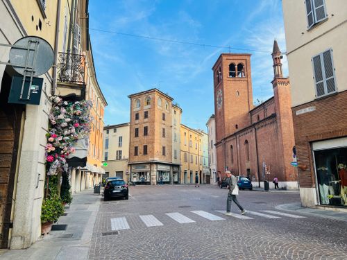 Free Picturesque street scene in Piacenza with historic buildings and vibrant flowers. Stock Photo
