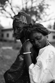 Black and white portrait of a couple in traditional clothing, showcasing emotion and connection.