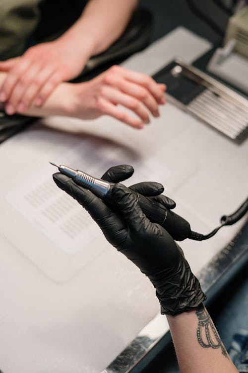 Person in Black Leather Gloves Holding Black Pen