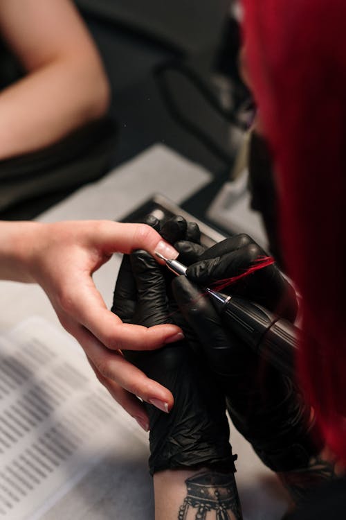 Person in Black Leather Gloves Holding Black Smartphone